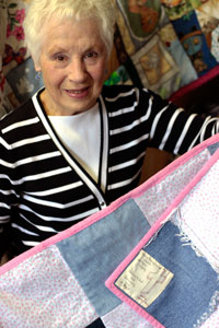Norma Hunchak showing off a quilt 